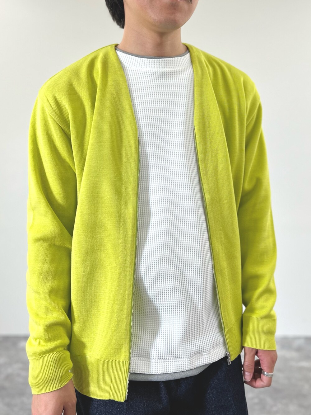 イエロー系のカーディガン/ボレロ、ホワイト系のTシャツ/カットソー、ブルー系のデニムパンツを着用したメンズの冬コーディネートの8枚目の写真