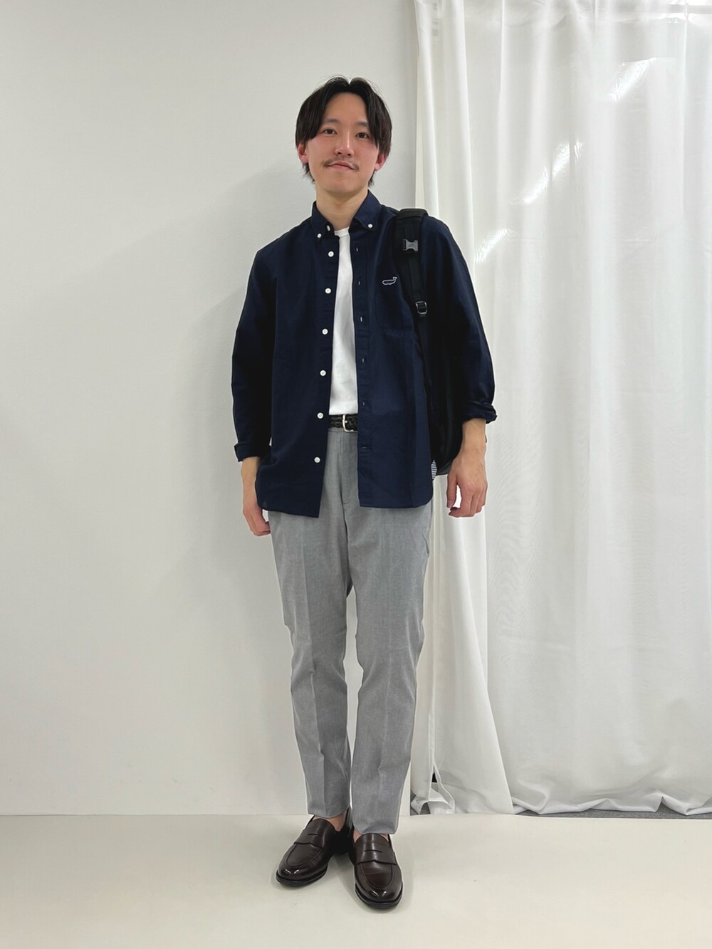 ブルー系のシャツ/ブラウス、ブラウン系のローファー、グレー系のチノパンツを着用したメンズの春コーディネートの3枚目の写真