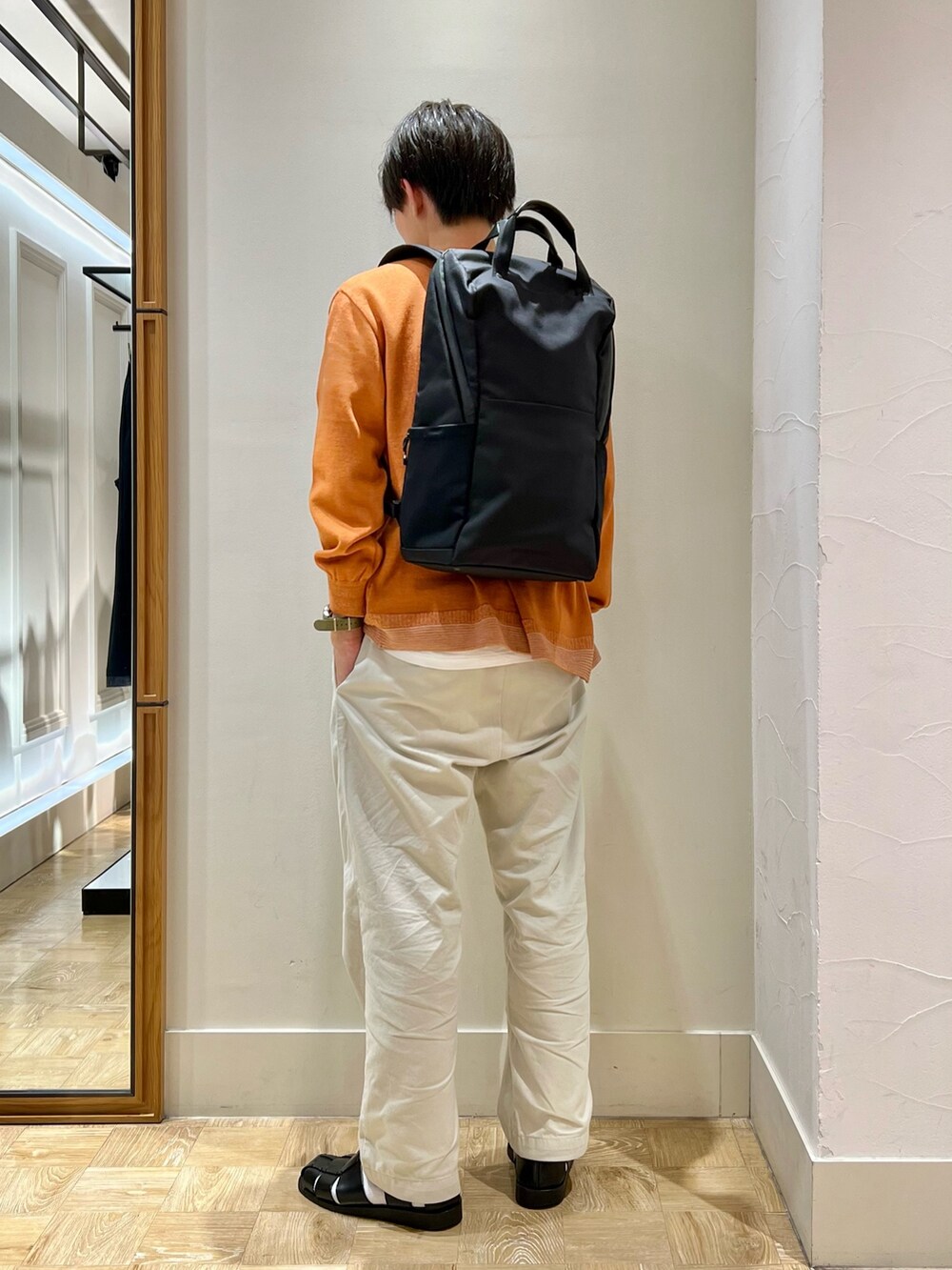 イエロー系のカーディガン/ボレロ、ブラック系のバックパック/リュックを着用したメンズの秋コーディネートの3枚目の写真