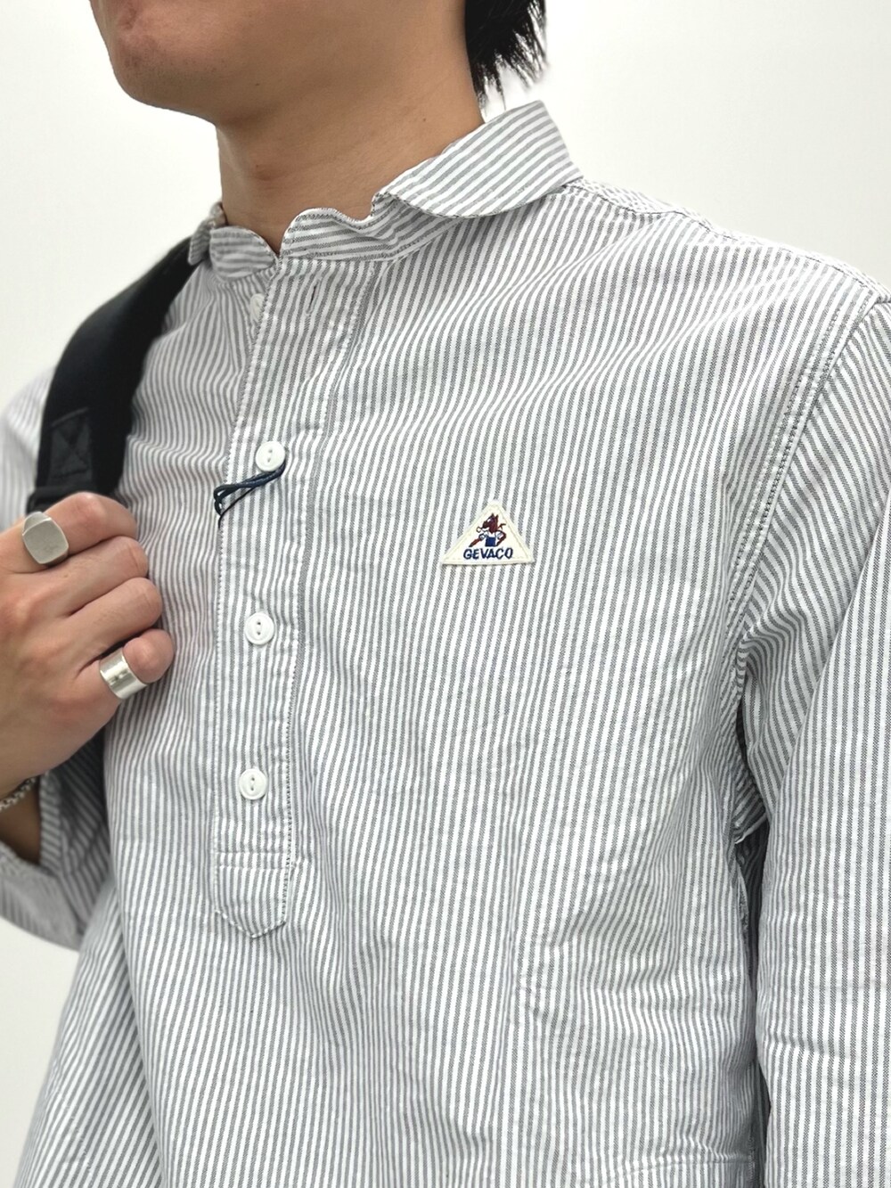 ブラック系のシャツ/ブラウス、ベージュ系のチノパンツ、ブラック系のバックパック/リュックを着用したメンズの春コーディネートの5枚目の写真