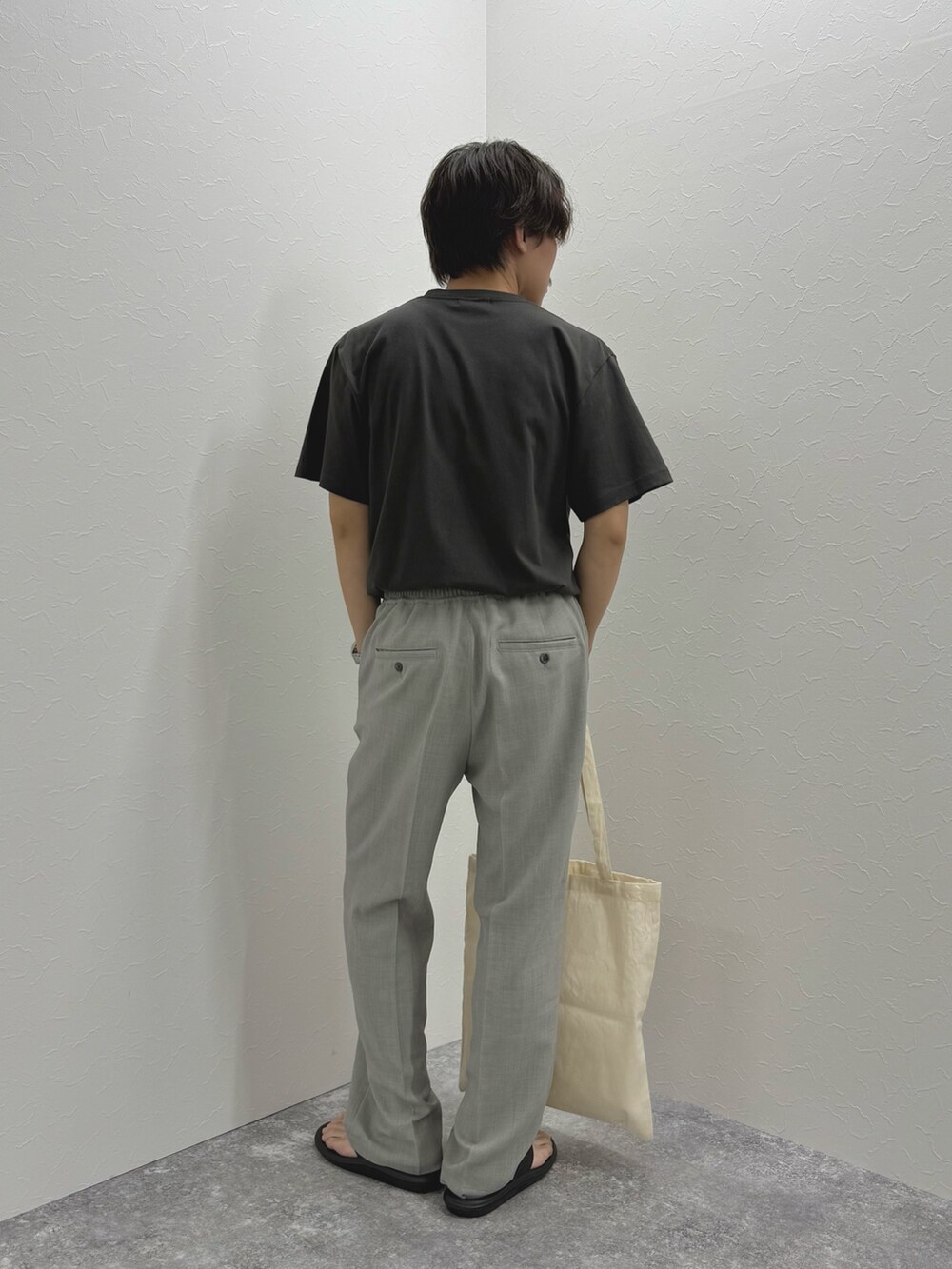 ブラック系のTシャツ/カットソー、ホワイト系のトートバッグ、ブラック系のサンダルを着用したメンズの夏コーディネートの8枚目の写真