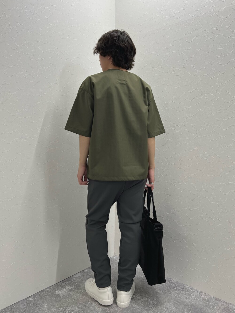 グリーン系のTシャツ/カットソー、ブラック系のトートバッグ、グレー系のその他パンツを着用したメンズの春コーディネートの6枚目の写真