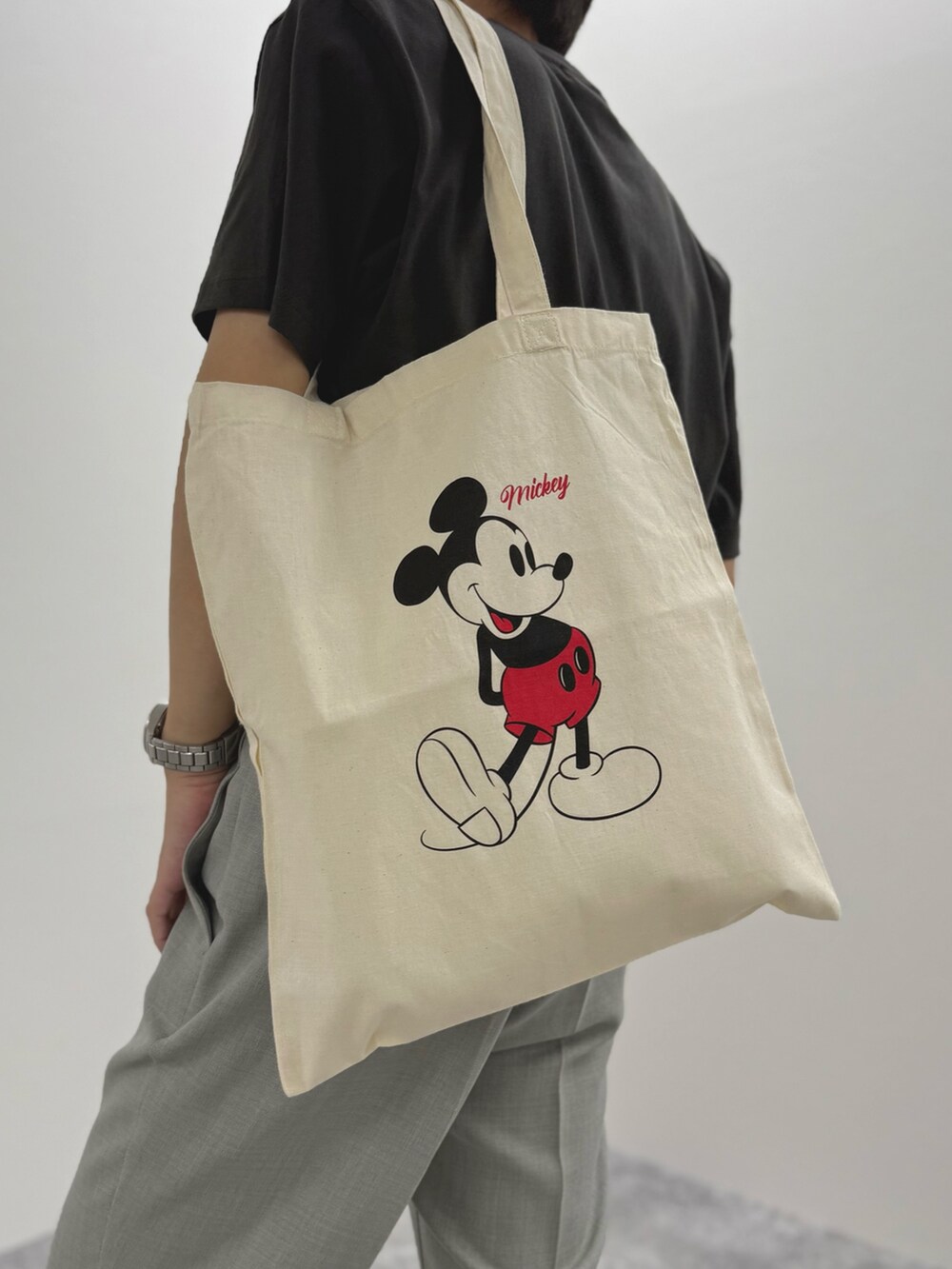 ブラック系のTシャツ/カットソー、ホワイト系のトートバッグ、ブラック系のサンダルを着用したメンズの夏コーディネートの9枚目の写真