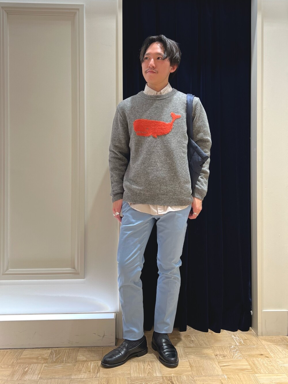 グレー系のニット/セーター、ベージュ系のシャツ/ブラウス、ブルー系のチノパンツを着用したメンズの冬コーディネートの2枚目の写真