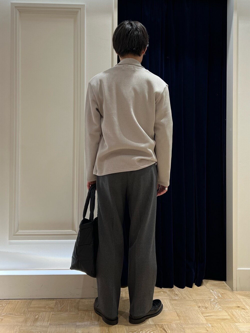 ベージュ系のカーディガン/ボレロ、ベージュ系のTシャツ/カットソー、ブラック系のトートバッグを着用したメンズの冬コーディネートの4枚目の写真