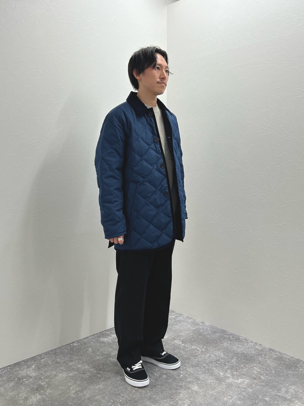 ブルー系のダウンジャケット/コート、ベージュ系のスウェット、ブラック系のスニーカーを着用したメンズの秋コーディネートの3枚目の写真