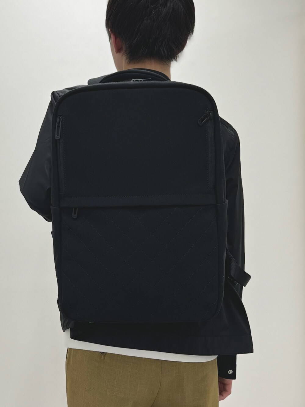 ブラック系のブルゾン、ベージュ系のその他パンツ、ブラック系のサンダルを着用したメンズの春コーディネートの5枚目の写真