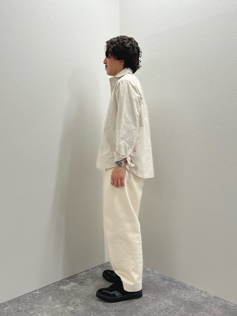 ホワイト系のシャツ/ブラウス、ホワイト系のデニムパンツ、ブラック系のスニーカーを着用したメンズの春コーディネートの4枚目の写真