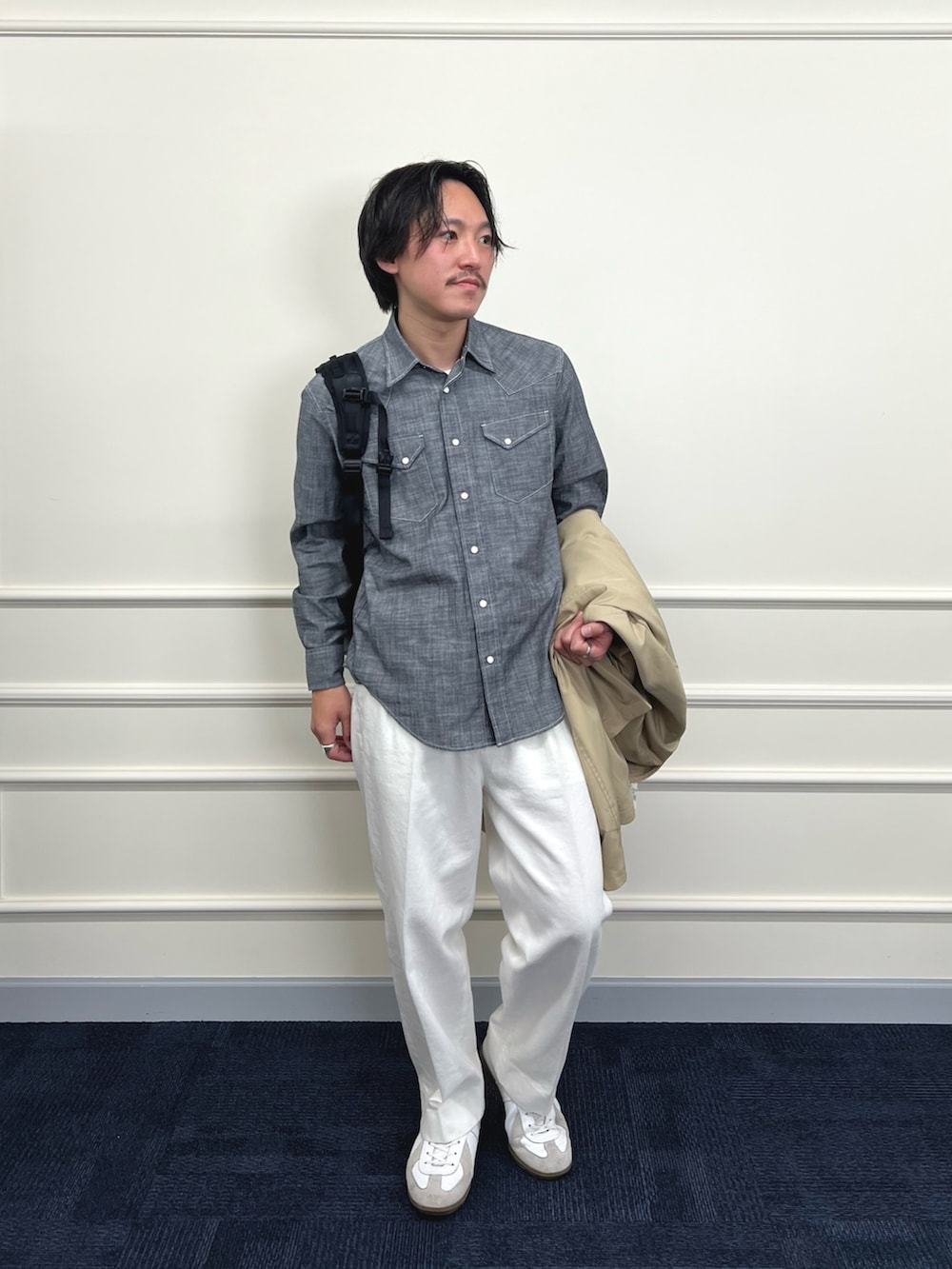 ベージュ系のステンカラーコート、ブラック系のシャツ/ブラウス、ホワイト系のデニムパンツを着用したメンズの冬コーディネートの3枚目の写真