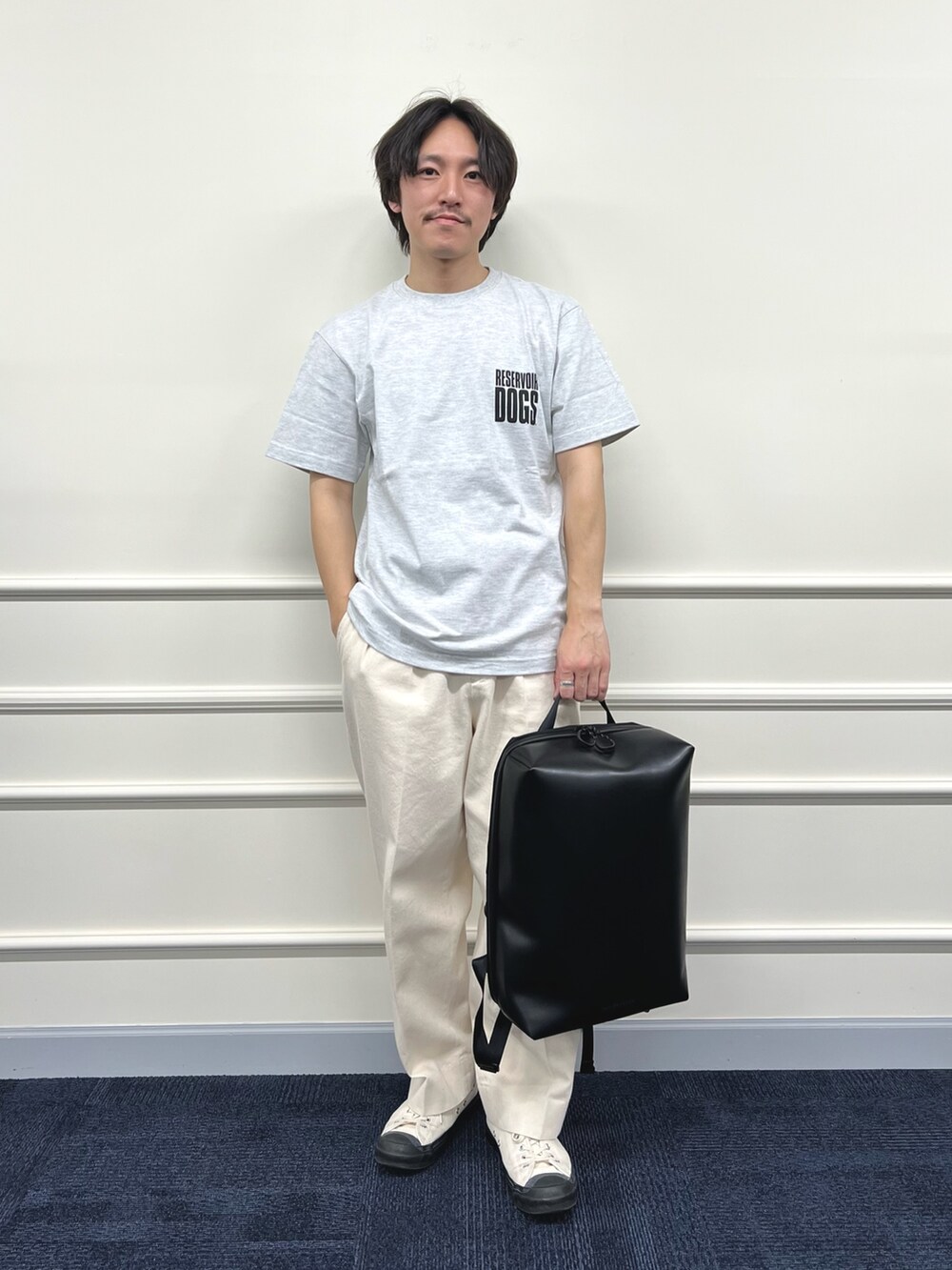 グレー系のTシャツ/カットソー、ブラック系のバックパック/リュック、ホワイト系のデニムパンツを着用したメンズの冬コーディネートの3枚目の写真