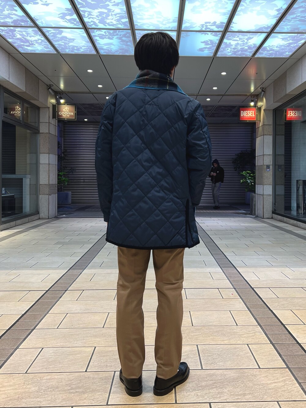 ブルー系のダウンジャケット/コート、ベージュ系のチノパンツ、ブルー系のニット/セーターを着用したメンズの冬コーディネートの4枚目の写真