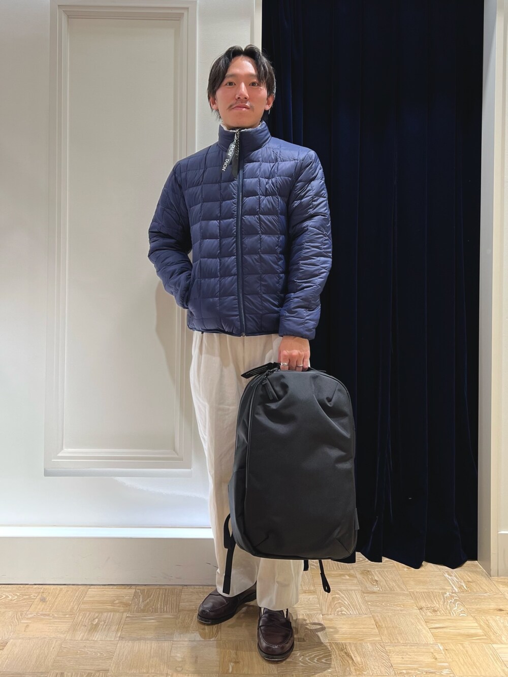 ホワイト系のダウンジャケット/コート、ブラック系のバックパック/リュックを着用したメンズの冬コーディネートの2枚目の写真