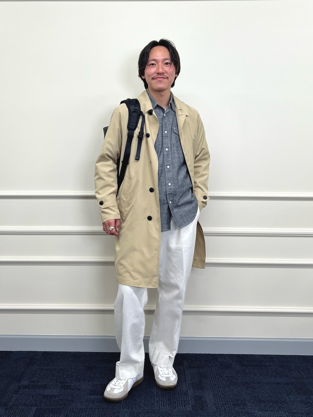 ベージュ系のステンカラーコート、ブラック系のシャツ/ブラウス、ホワイト系のデニムパンツを着用したメンズの冬コーディネートの6枚目の写真