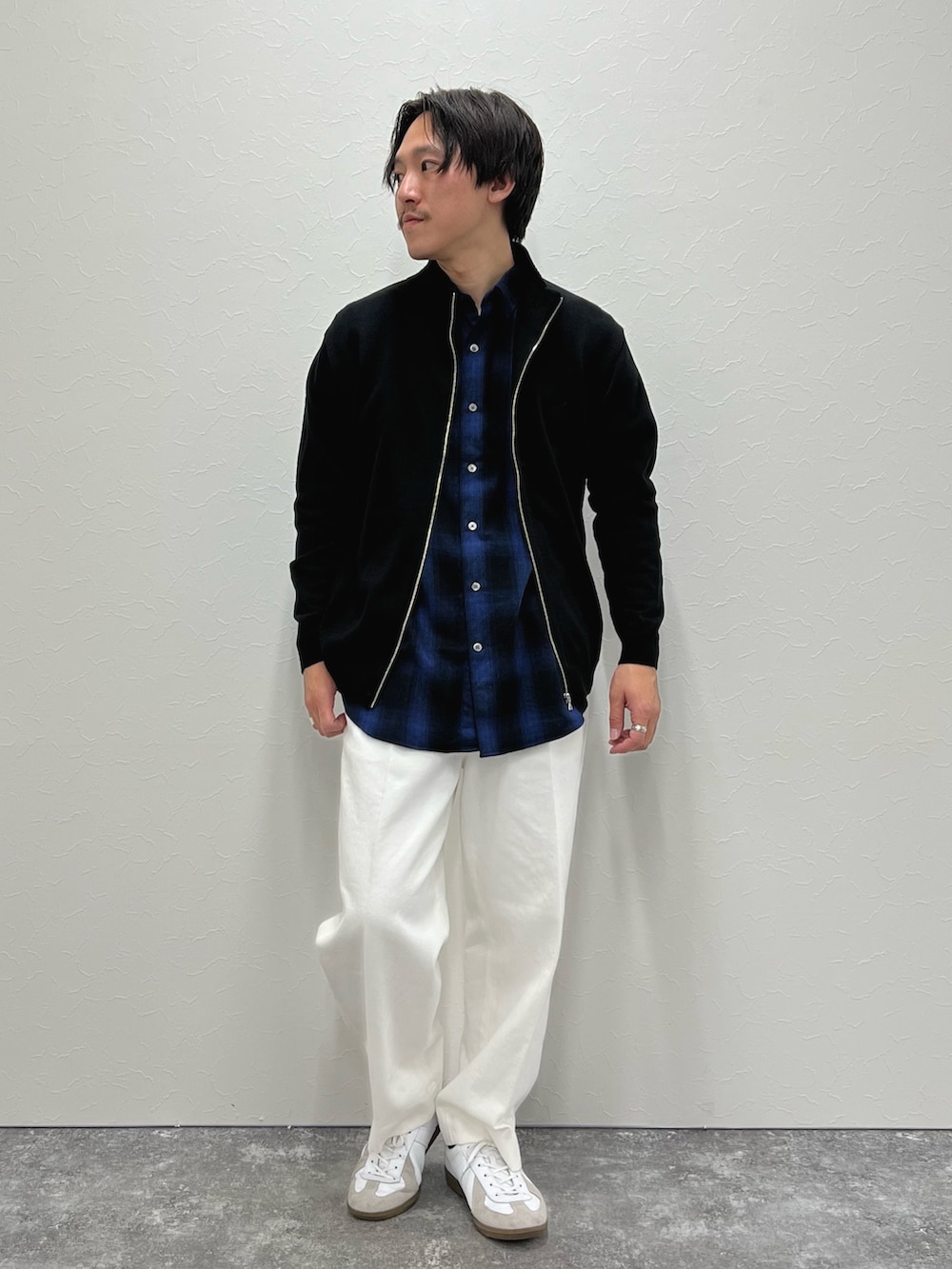ブラック系のカーディガン/ボレロ、ブルー系のシャツ/ブラウス、ホワイト系のデニムパンツを着用したメンズの冬コーディネートの4枚目の写真