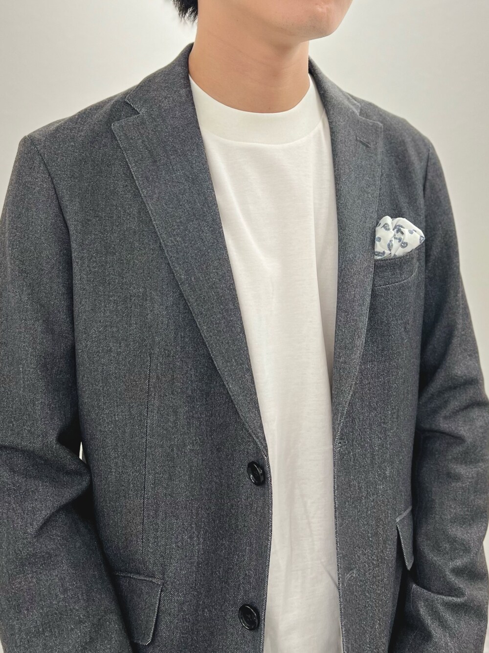 グレー系のテーラードジャケット、ホワイト系のTシャツ/カットソー、グレー系のその他パンツを着用したメンズの秋コーディネートの7枚目の写真