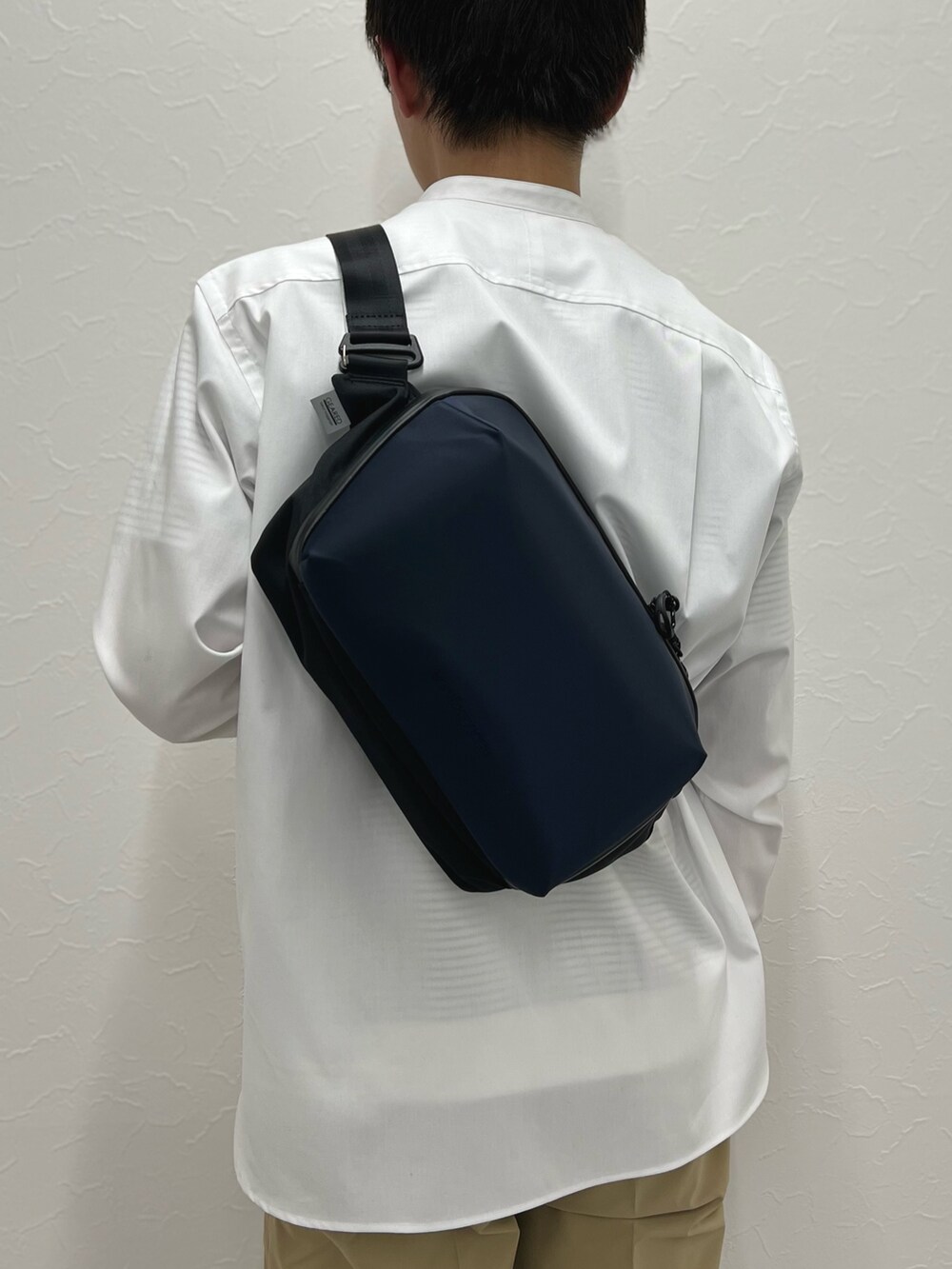 ホワイト系のシャツ/ブラウス、ベージュ系のその他パンツ、ブルー系のショルダーバッグを着用したメンズの春コーディネートの7枚目の写真