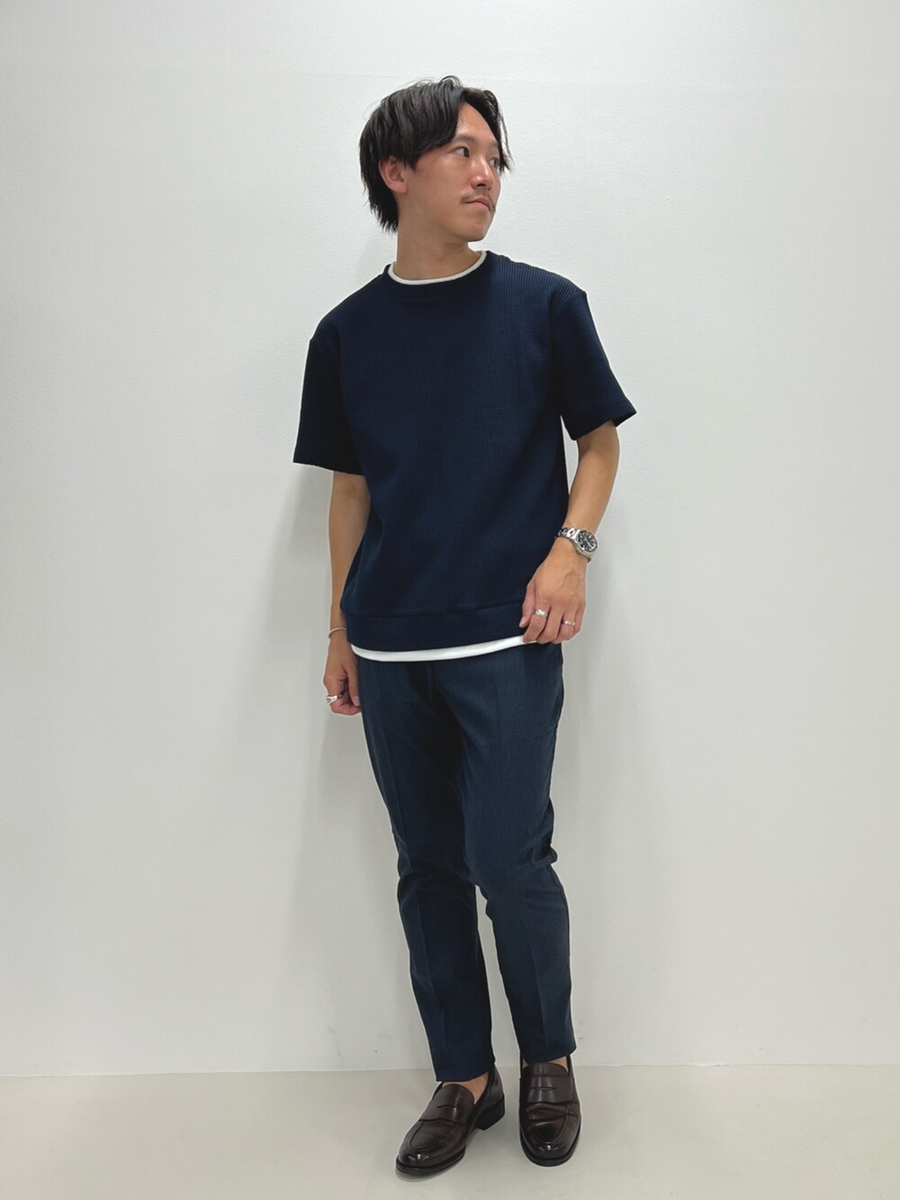 ブルー系のTシャツ/カットソー、ブルー系のチノパンツ、ブラウン系のローファーを着用したメンズの夏コーディネートの2枚目の写真