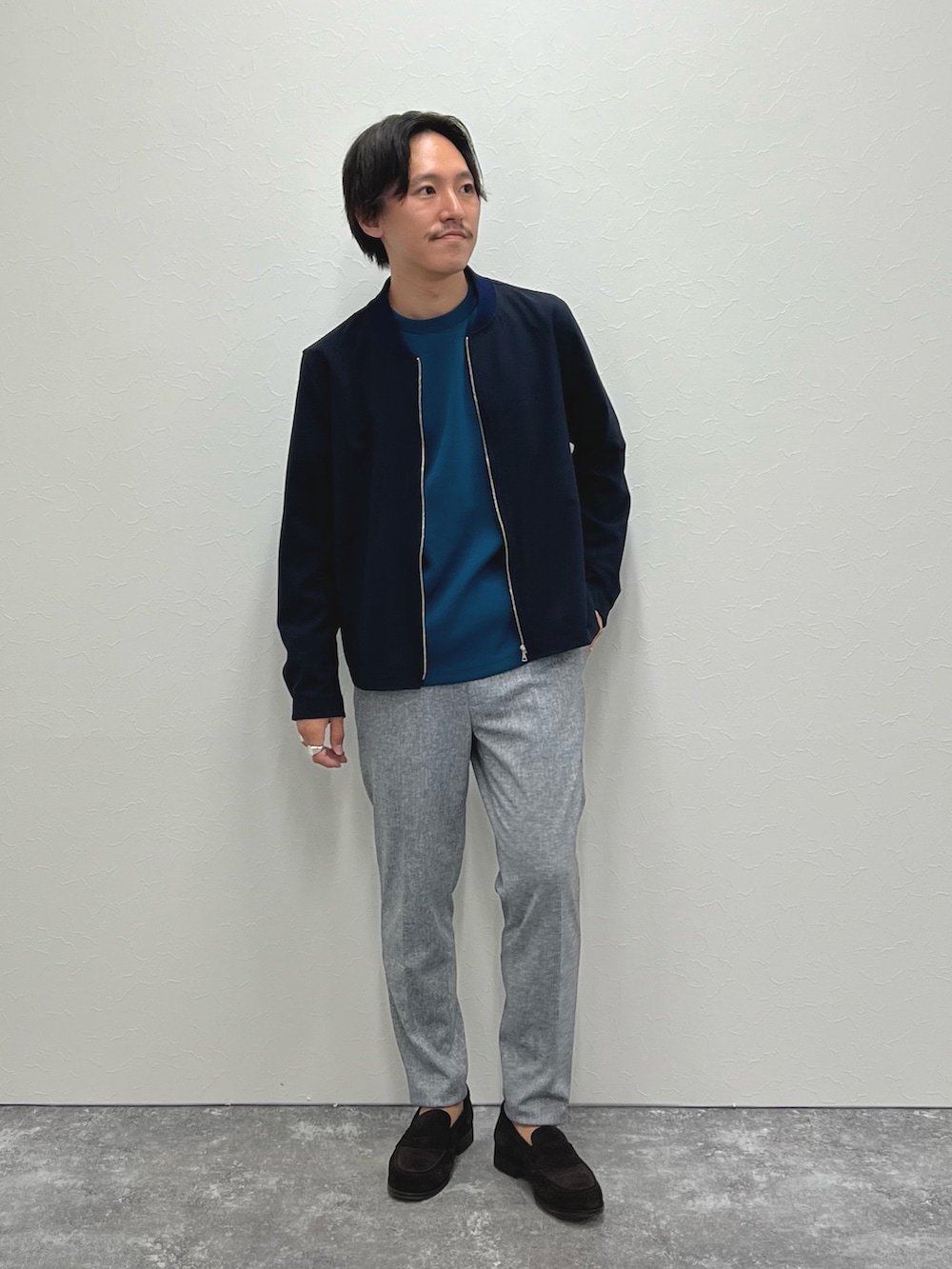 ブルー系のブルゾン、ブルー系のTシャツ/カットソー、グレー系のその他パンツを着用したメンズの秋コーディネートの5枚目の写真