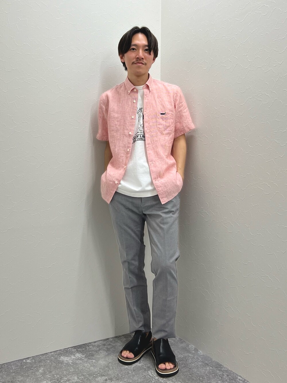 グレー系のチノパンツ、レッド系のシャツ/ブラウス、ホワイト系のTシャツ/カットソーを着用したメンズの夏コーディネートの2枚目の写真