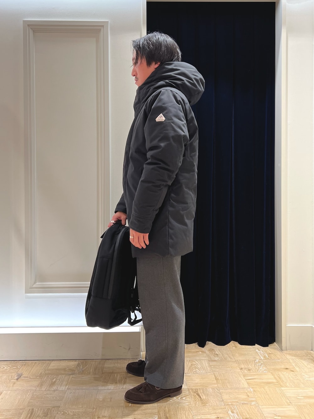 ブラック系のダウンジャケット/コート、グレー系のカーディガン/ボレロ、ブラック系のバックパック/リュックを着用したメンズの冬コーディネートの6枚目の写真