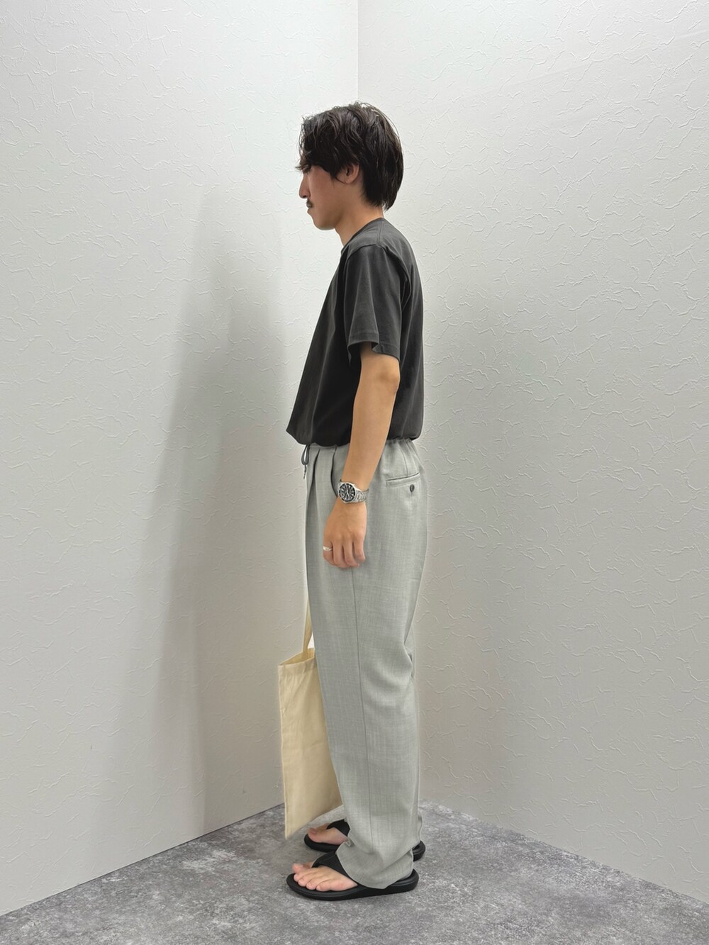 ブラック系のTシャツ/カットソー、ホワイト系のトートバッグ、ブラック系のサンダルを着用したメンズの夏コーディネートの7枚目の写真