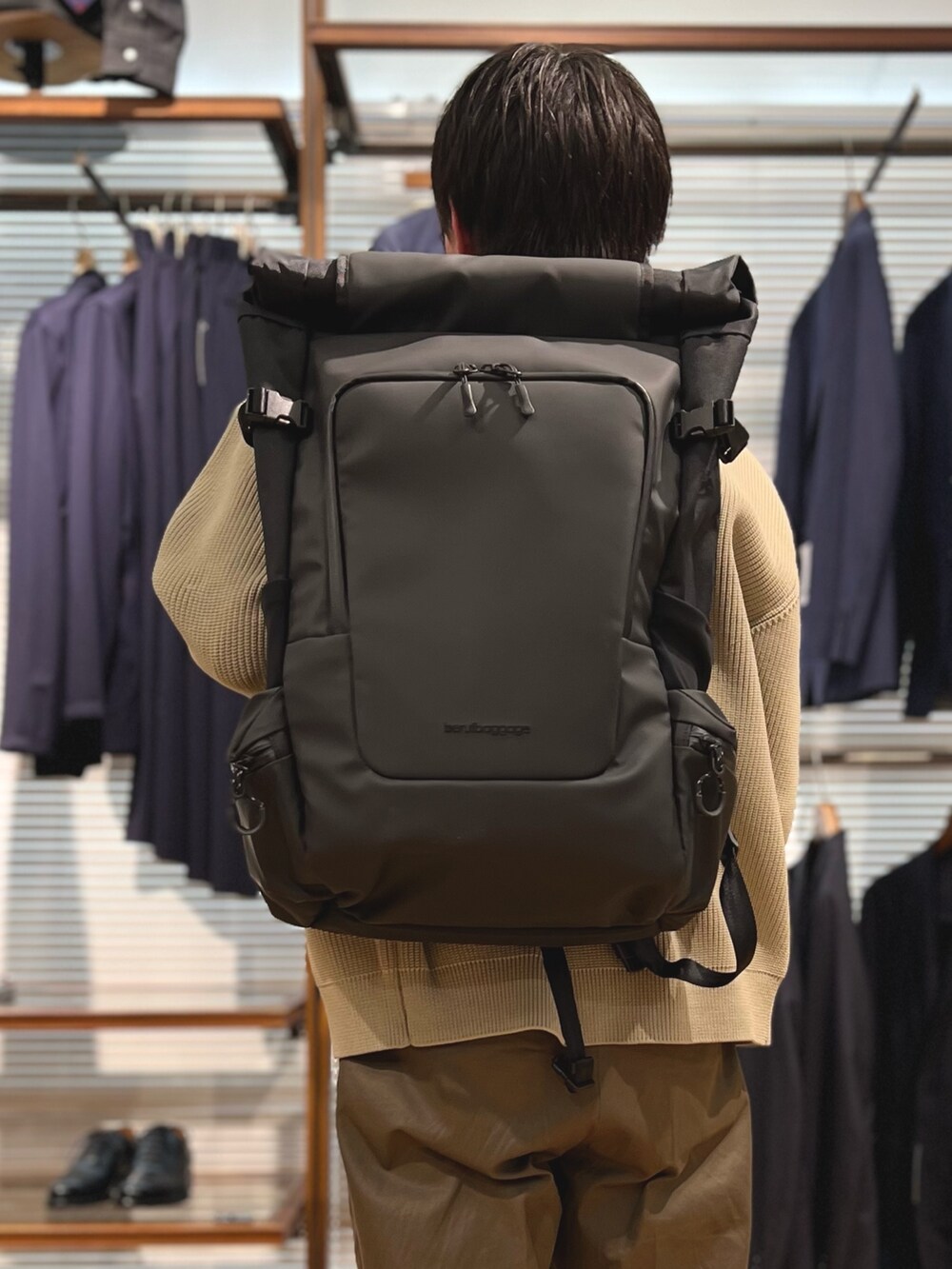 ベージュ系のカーディガン/ボレロ、ブラック系のバックパック/リュック、ブラック系のローファーを着用したメンズの春コーディネートの6枚目の写真