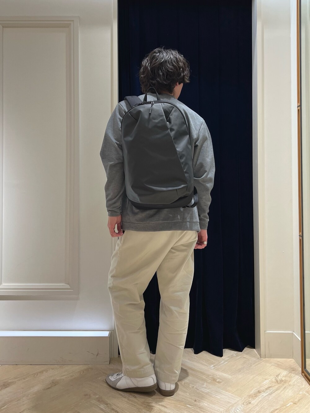 グレー系のカーディガン/ボレロ、ピンク系のTシャツ/カットソー、ブラック系のバックパック/リュックを着用したメンズの春コーディネートの4枚目の写真