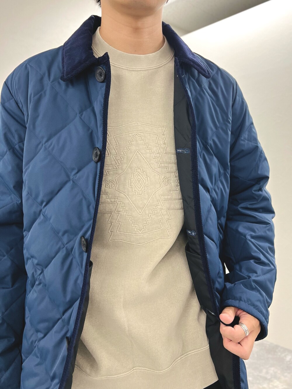 ブルー系のダウンジャケット/コート、ベージュ系のスウェット、ブラック系のスニーカーを着用したメンズの秋コーディネートの6枚目の写真