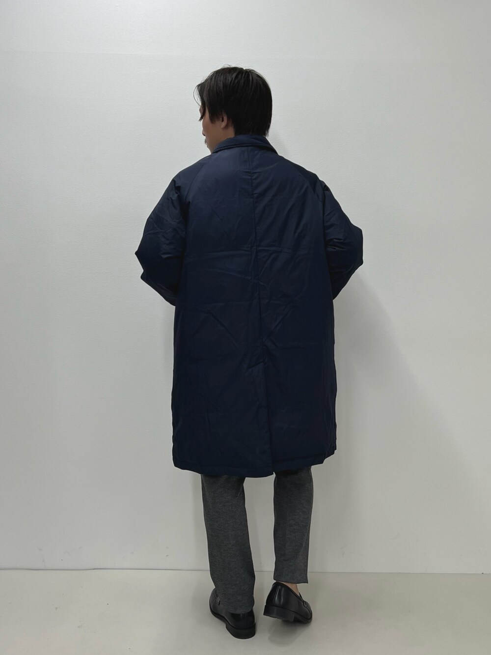 グレー系のその他パンツ、ブルー系のダウンジャケット/コート、ホワイト系のTシャツ/カットソーを着用したメンズの秋コーディネートの6枚目の写真