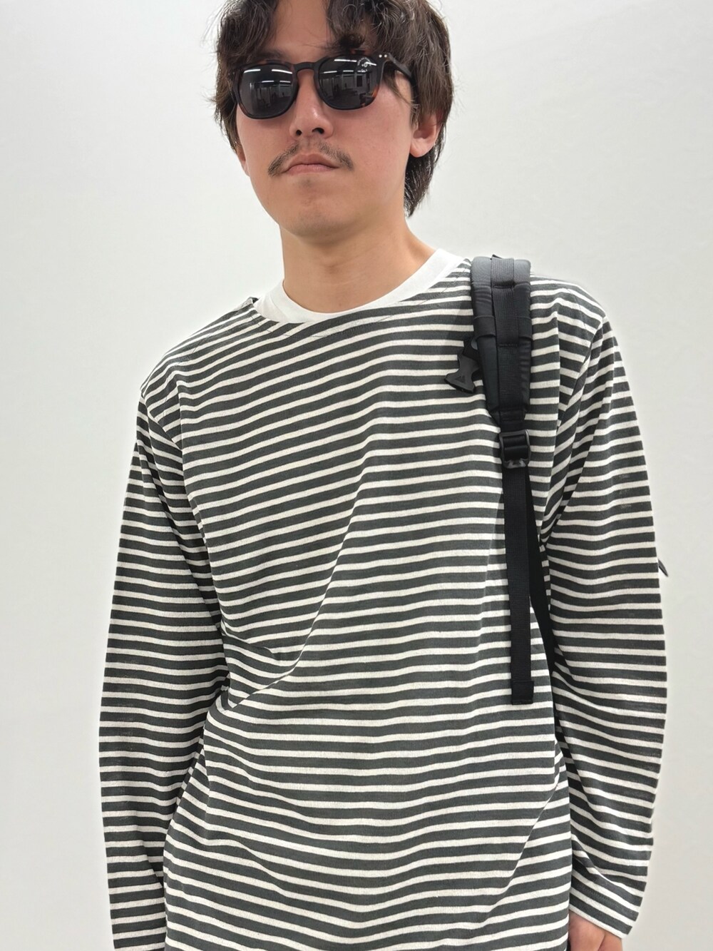 グレー系のTシャツ/カットソー、ホワイト系のその他パンツ、ブラック系のバックパック/リュックを着用したメンズの春コーディネートの8枚目の写真