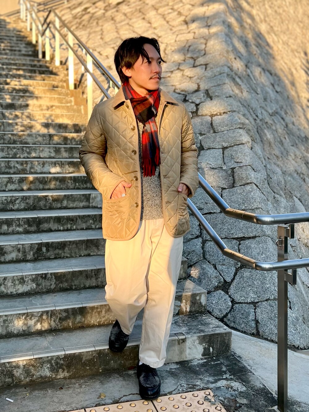 ベージュ系のブルゾン、ブルー系のマフラーを着用したメンズの秋コーディネートの2枚目の写真