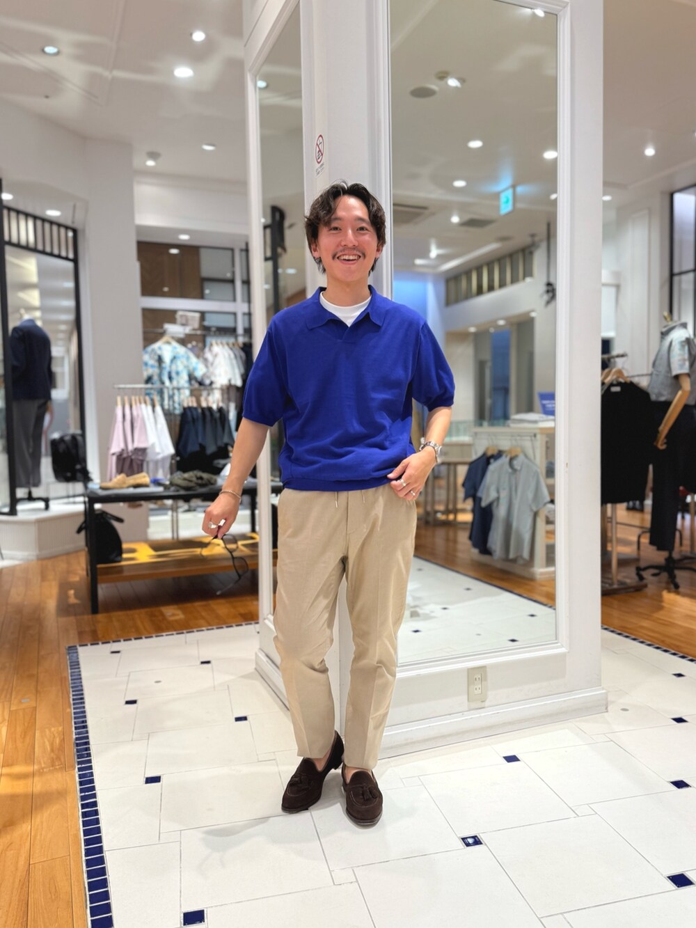 ブルー系のポロシャツ、ベージュ系のその他パンツ、ブラウン系のローファーを着用したメンズの春コーディネートの5枚目の写真