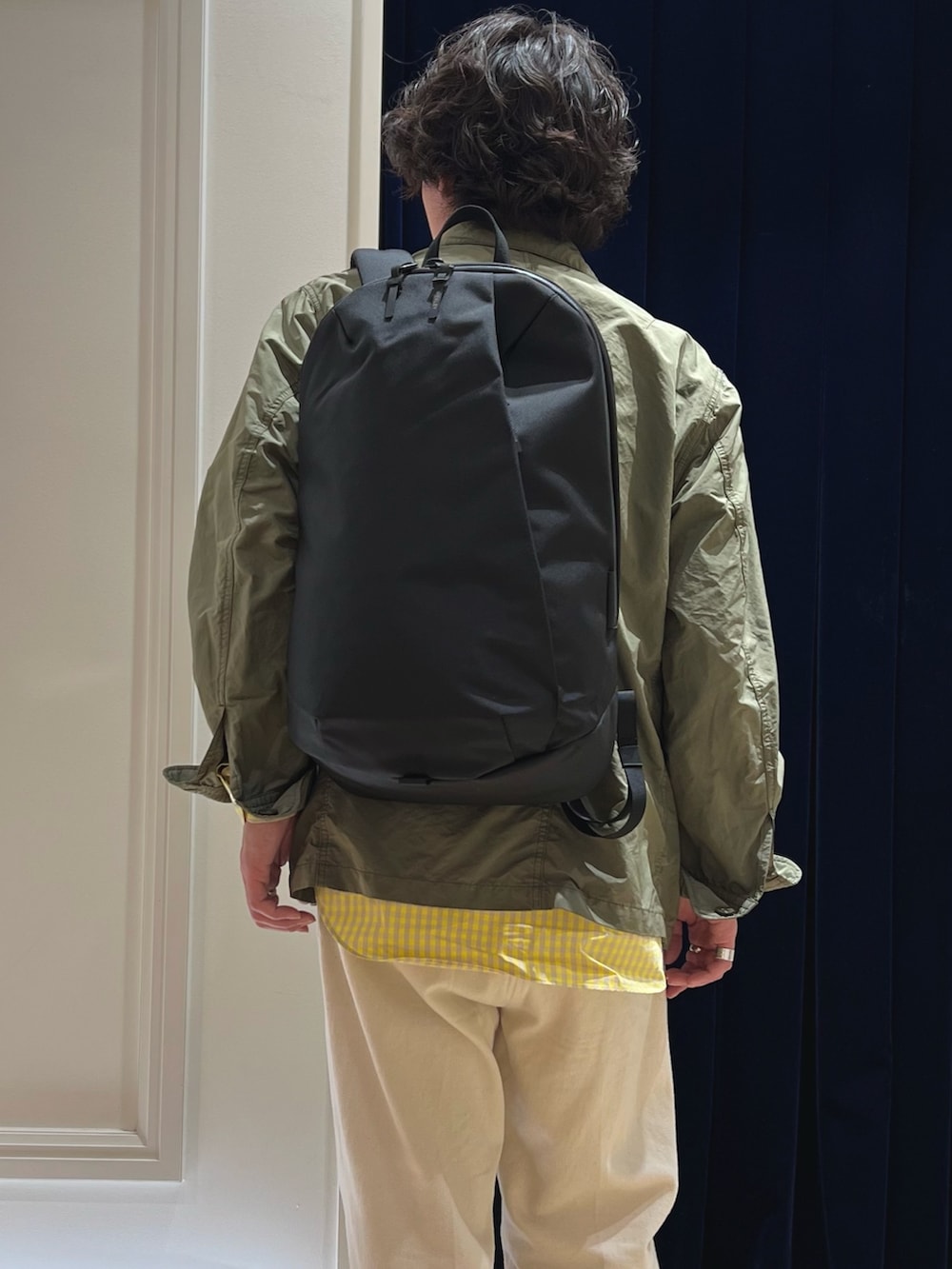 グリーン系のミリタリージャケット、レッド系のローファー、ホワイト系のデニムパンツを着用したメンズの春コーディネートの7枚目の写真