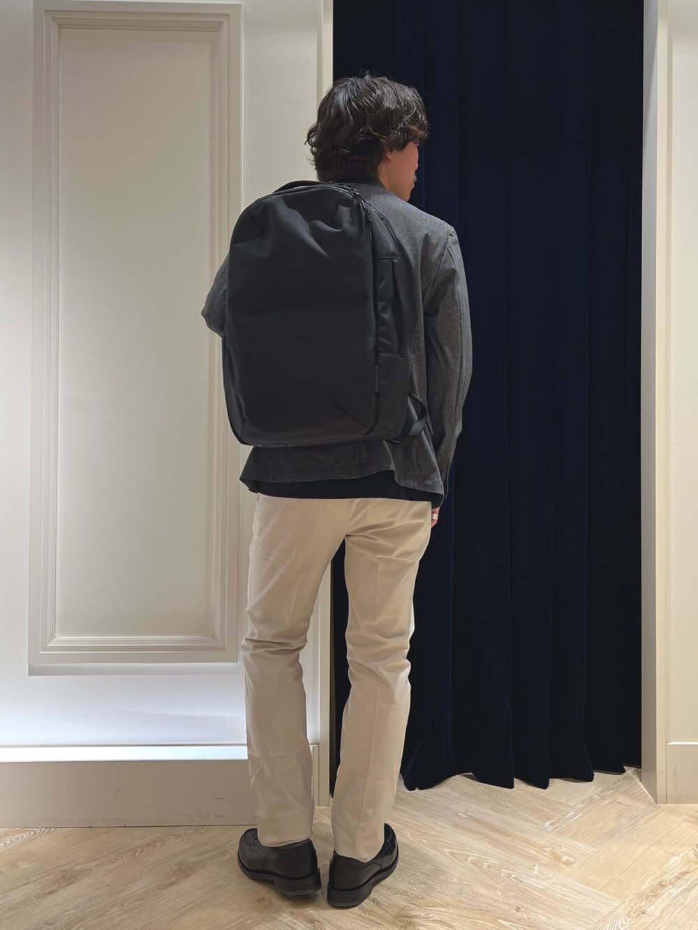 グレー系のテーラードジャケット、ブラック系のTシャツ/カットソー、ホワイト系のチノパンツを着用したメンズの春コーディネートの4枚目の写真