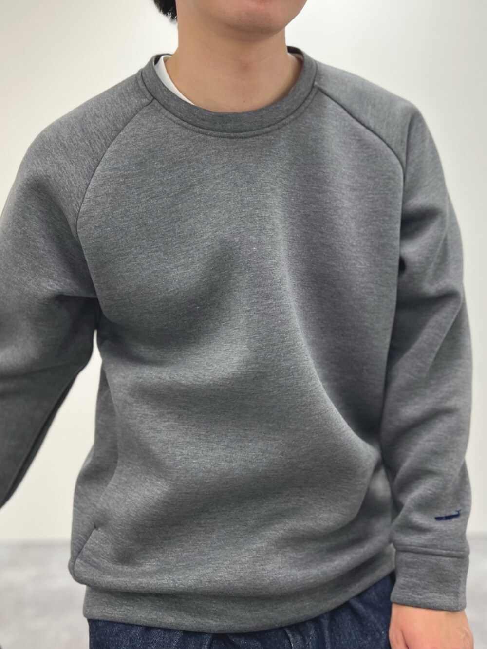 ブルー系のダウンジャケット/コート、ブルー系のデニムパンツ、グレー系のスウェットを着用したメンズの冬コーディネートの7枚目の写真