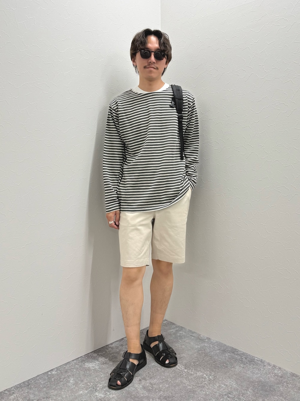 グレー系のTシャツ/カットソー、ホワイト系のその他パンツ、ブラック系のバックパック/リュックを着用したメンズの春コーディネートの3枚目の写真