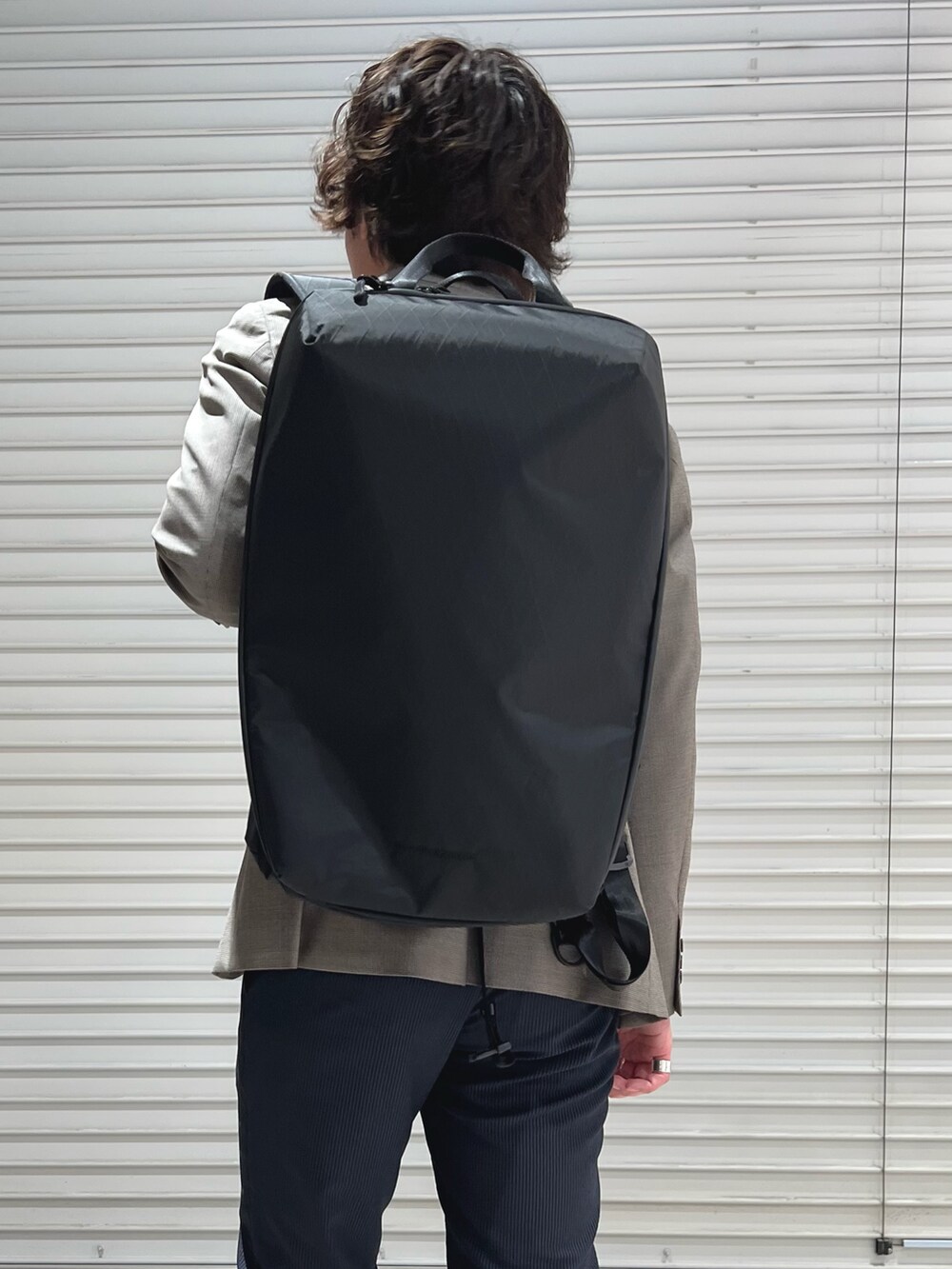 グレー系のテーラードジャケット、ホワイト系のTシャツ/カットソー、ブルー系のその他パンツを着用したメンズの春コーディネートの6枚目の写真