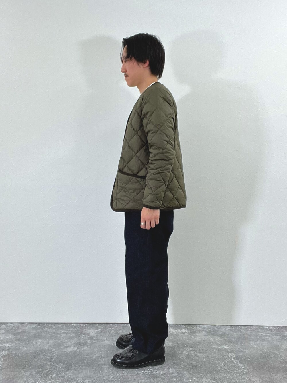 グリーン系のダウンジャケット/コート、ホワイト系のスウェット、ブラック系のブーツを着用したメンズの秋コーディネートの5枚目の写真