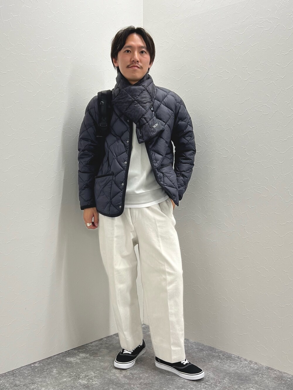 ブルー系のダウンジャケット/コート、グレー系のTシャツ/カットソー、ブルー系のマフラーを着用したメンズの秋コーディネートの3枚目の写真