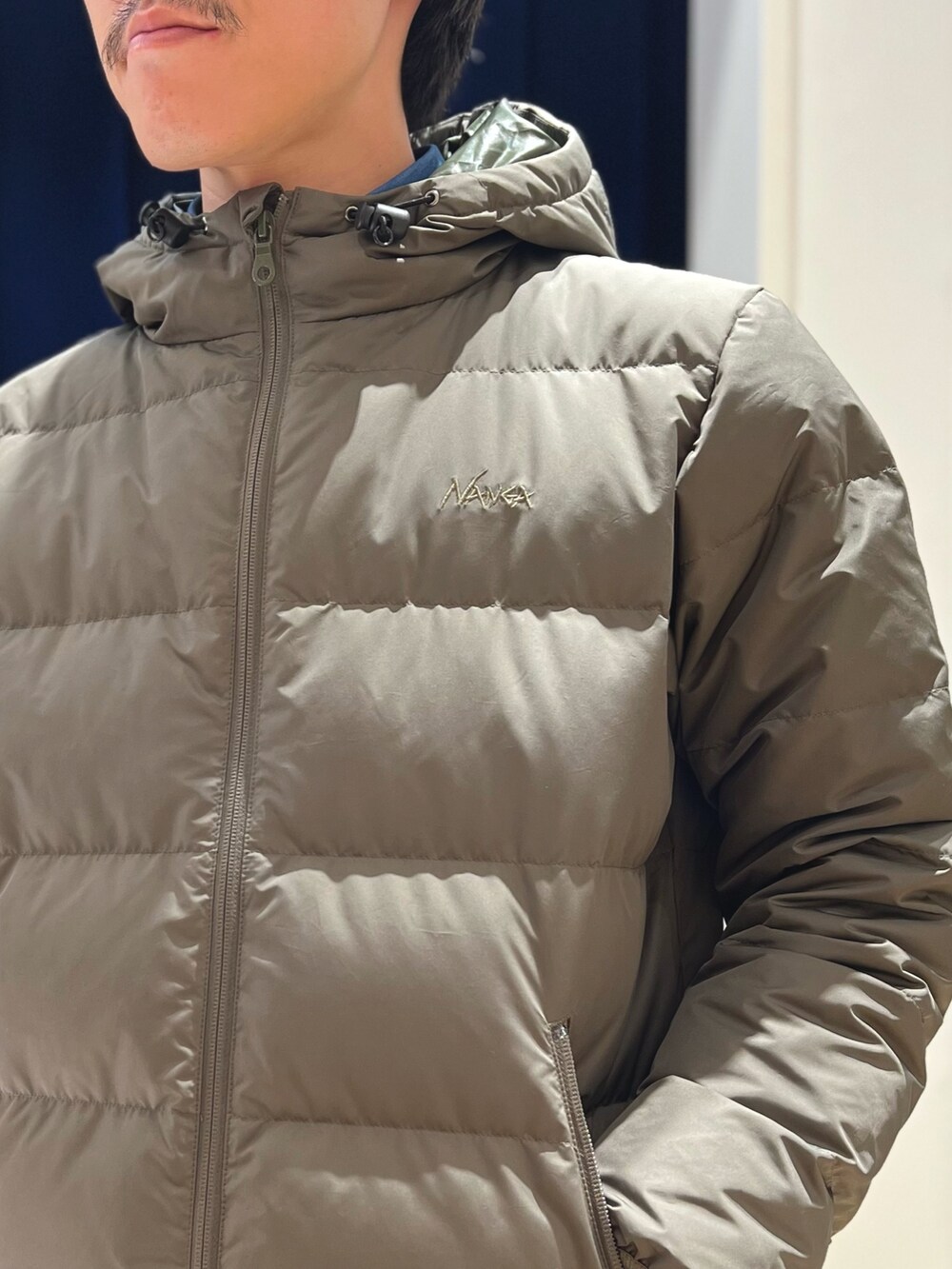 グリーン系のダウンジャケット/コート、ブルー系のシャツ/ブラウス、ブラック系のその他パンツを着用したメンズの秋コーディネートの6枚目の写真