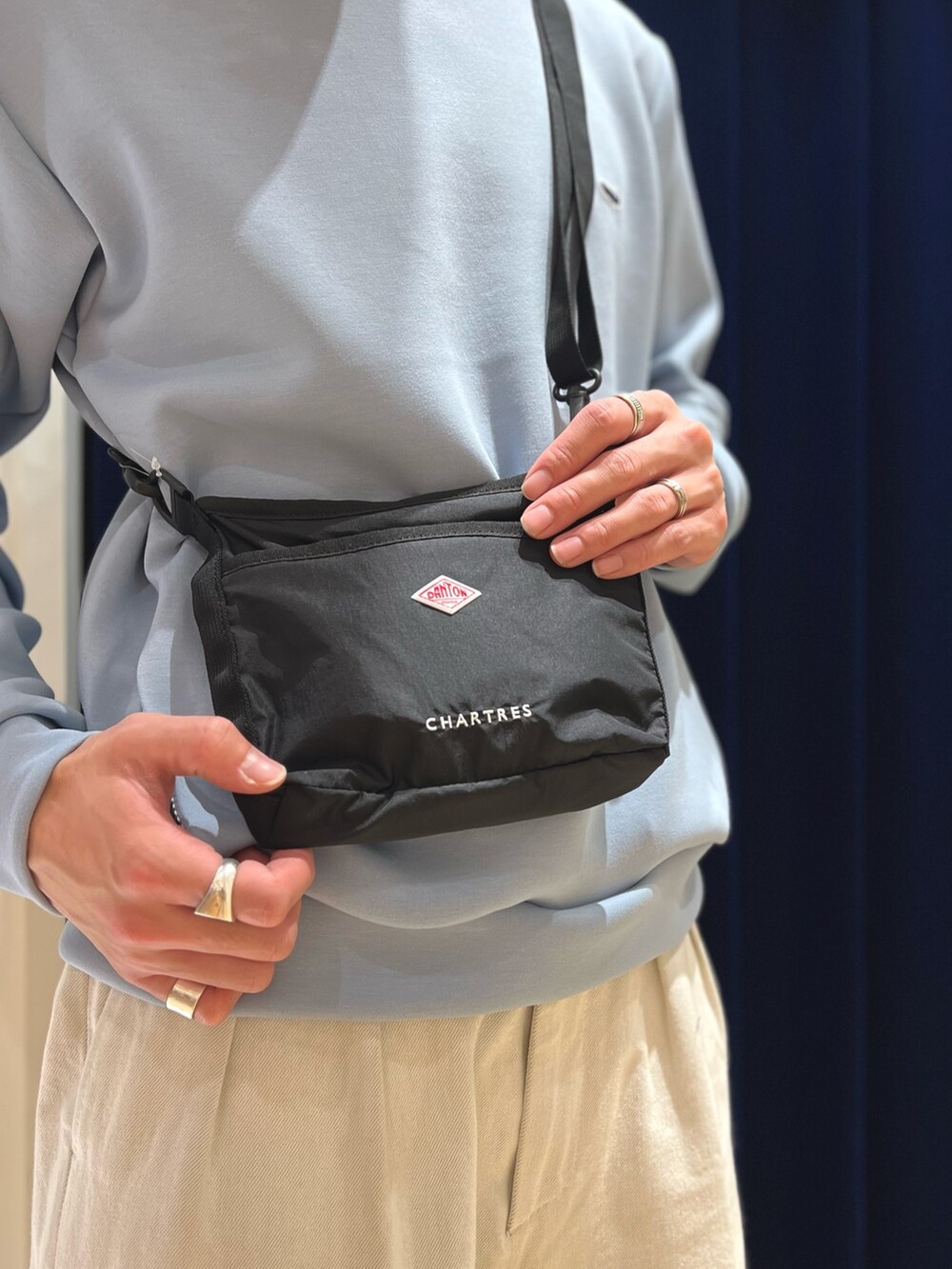 ブルー系のスウェット、ブラック系のショルダーバッグ、ブラック系のシューズを着用したメンズの春コーディネートの6枚目の写真