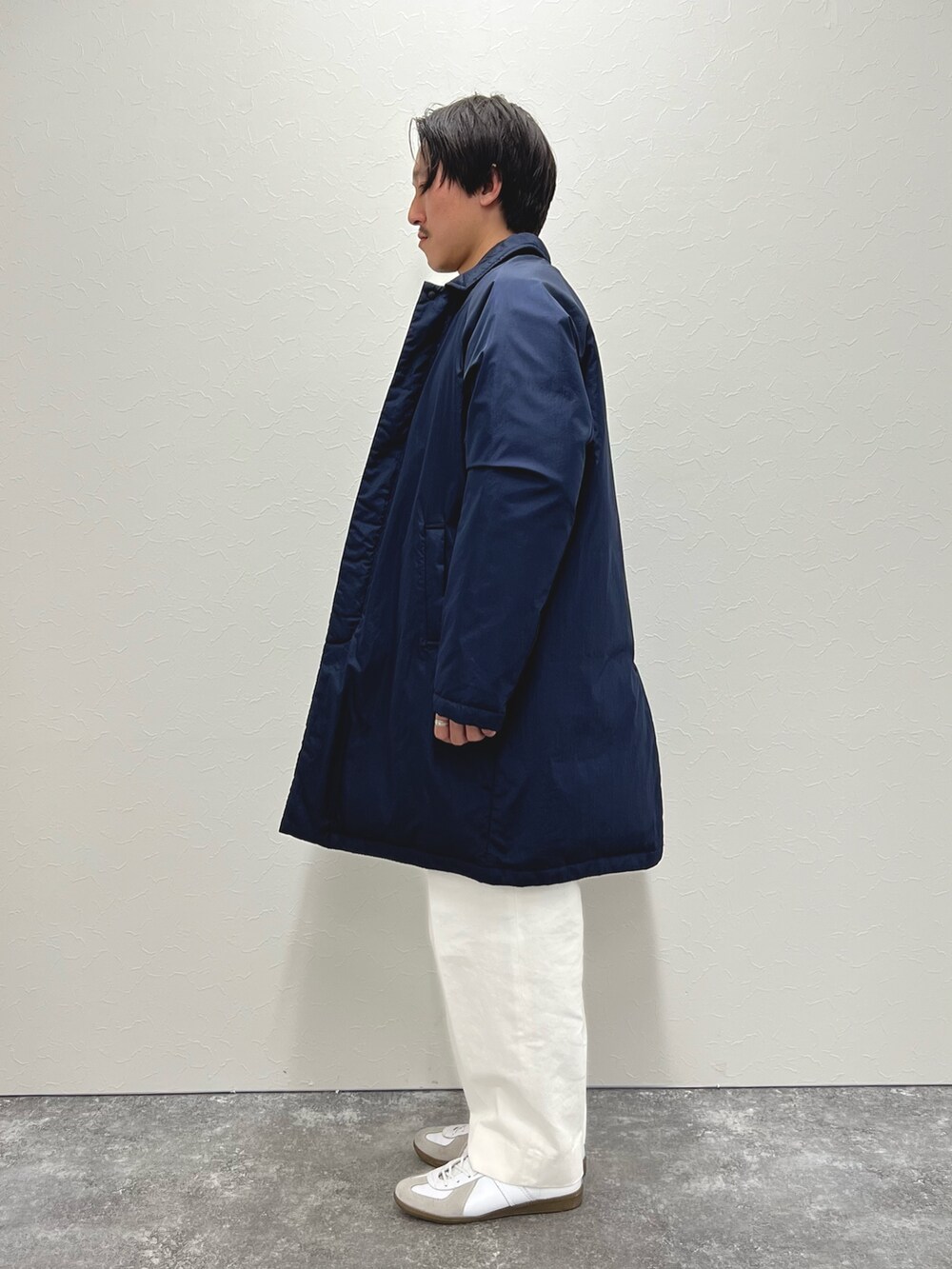 ブルー系のダウンジャケット/コート、グレー系のニット/セーター、グリーン系のシャツ/ブラウスを着用したメンズの冬コーディネートの5枚目の写真