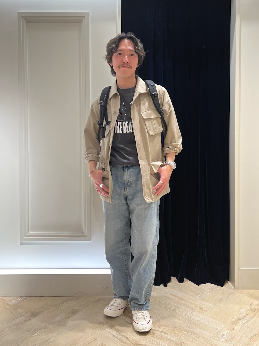 ベージュ系のミリタリージャケット、ブラック系のTシャツ/カットソー、ブラック系のバックパック/リュックを着用したメンズの春コーディネートの5枚目の写真