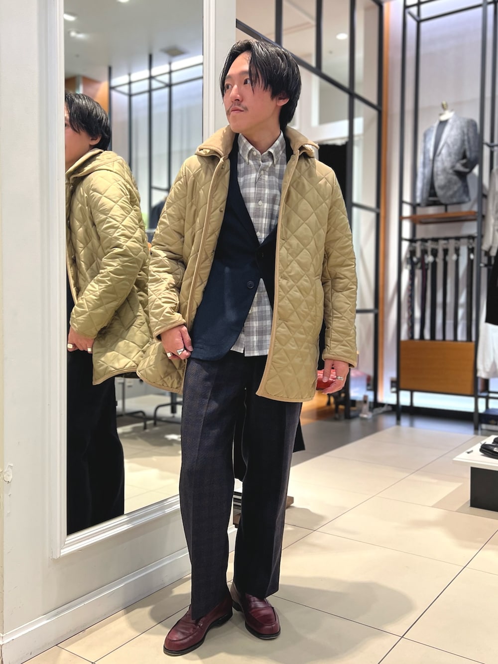 ベージュ系のブルゾン、ブルー系のテーラードジャケット、ブラウン系のローファーを着用したメンズの冬コーディネートの4枚目の写真