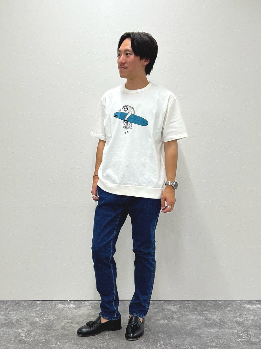 ホワイト系のTシャツ/カットソー、ブルー系のデニムパンツ、ブラック系のローファーを着用したメンズの夏コーディネートの2枚目の写真