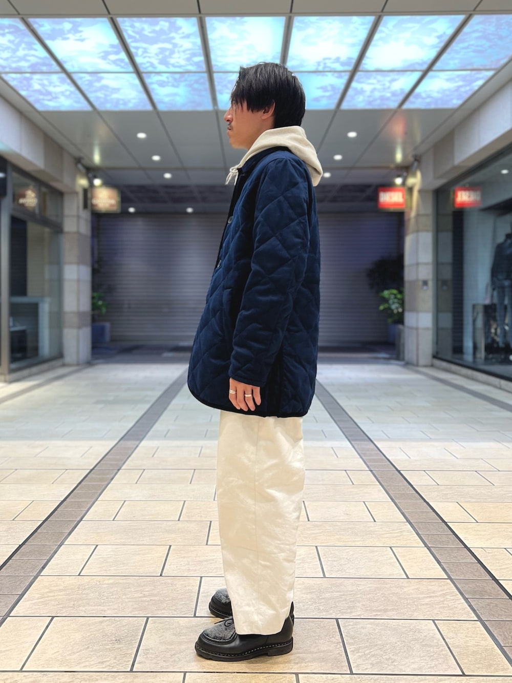 ホワイト系のパーカー、ブルー系のダウンジャケット/コート、ブラック系のシューズを着用したメンズの冬コーディネートの3枚目の写真