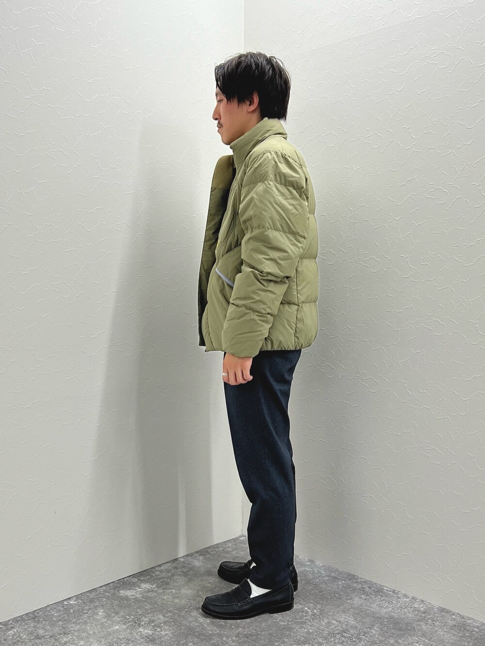 グリーン系のダウンジャケット/コート、ブルー系のTシャツ/カットソー、グレー系のその他パンツを着用したメンズの秋コーディネートの4枚目の写真