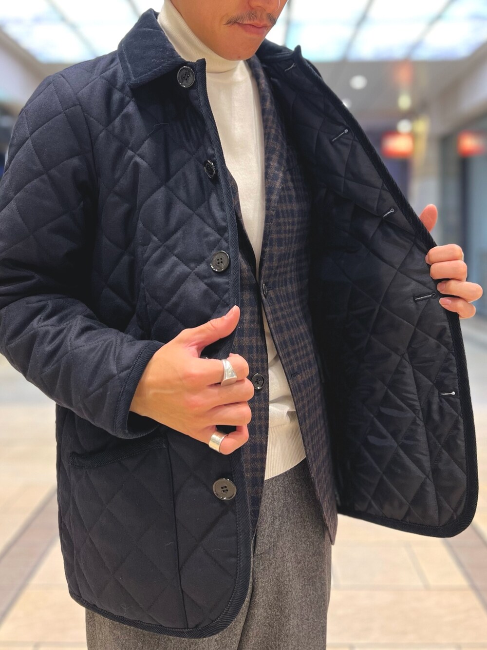 ブルー系のテーラードジャケット、ホワイト系のニット/セーター、ブラウン系のローファーを着用したメンズの冬コーディネートの6枚目の写真