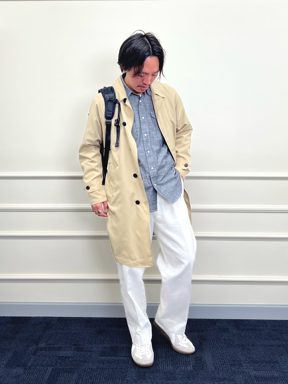 ベージュ系のステンカラーコート、ブラック系のシャツ/ブラウス、ホワイト系のデニムパンツを着用したメンズの冬コーディネートの5枚目の写真