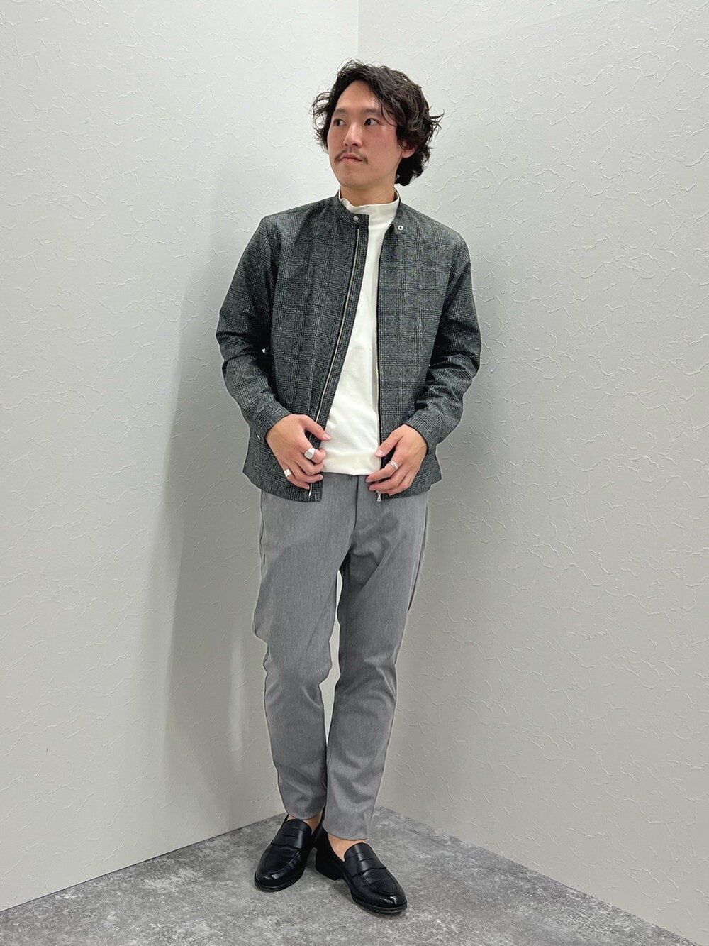 グレー系のブルゾン、ホワイト系のTシャツ/カットソー、グレー系のチノパンツを着用したメンズの冬コーディネートの4枚目の写真